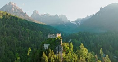 Dolomite Alplerindeki eski bir kalenin havadan görünüşü. Gün batımında bir kayanın üzerindeki güzel tarihi kale bir dağ manzarasında. Yüksek kalite 4k görüntü