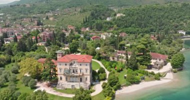 İtalya 'daki Garda Gölü üzerindeki Toscolano Maderno şehrinin havadan görünüşü. Dolomite Alplerinde bir turist kasabasının mimarisi. Yüksek kalite 4k görüntü