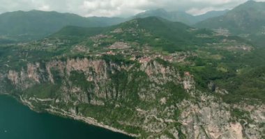 İtalya Garda Pieve Gölü 'nün havadan görünüşü. Alp Dağları 'nın güzel doğa manzarası. Gölün kıyısında kayalıklar ve kayalar var. Yüksek kalite 4k görüntü