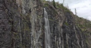 İtalya 'daki Dolomite Alpleri' nde bir şelalenin havadan görünüşü. Bir dağ nehri, doğanın inanılmaz bir manzarasında kayalardan aşağı düşer. Avrupa 'nın turistik yerleri. Yüksek kalite 4k görüntü