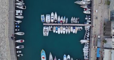 Limanda tekneleri ve yatları olan güzel bir marinanın havadan görüntüsü. Suda lüks tatiller. Yüksek kalite 4k görüntü
