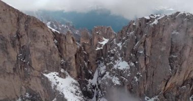 Dolomite Alplerindeki Rosengarten Grubu 'nun İHA görüntüleri: Majestic Snowy Peaks ve Bulut Kaplamalı Rocky Mountain Manzarası. Yüksek kalite 4k görüntü