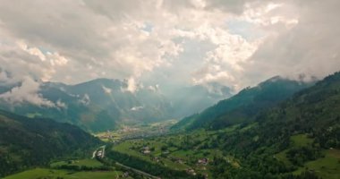 Alplerin doğa manzarasının havadan görünüşü. Dağ sıraları ve zirveler büyülü bir şekilde bulutlarla örtülüdür. Yüksek kalite 4k görüntü