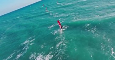 Okyanusta rüzgar sörfünün hava görüntüsü - Aktif Deniz Sporları Dalgalarda yelkenli ile. Yüksek kalite 4k görüntü