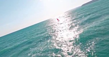 Kıbrıs adasındaki Akdeniz 'de rüzgar sörfünün hava görüntüsü: Dalgalarda Heyecanlı Su Sporları Macerası, Sahne Sahili' nde Aktif Eğlence, Seyahat ve Turizmi Vurguluyor. 
