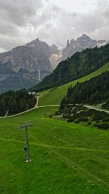 İtalya 'daki Dolomite Alpleri' nin doğa manzarası. Tepelerin eteklerindeki yeşil vadiler ve kayalık dağ sıraları. Dikey video. Yüksek kalite 4k görüntü