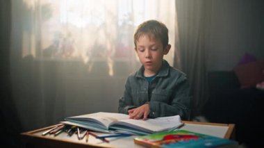 Çocuk Odasında Çocuk Okuma Kitabı - Beyaz Çocuğun Sayfaları Çevirip Keşfetmesi. Yüksek kalite 4k görüntü