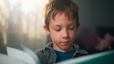 Genç Kafkasyalı Çocuk Bir Kitap Okumakla meşgul - Evinde Sayfayı Çevir ve Öğren 'in Yakın Çekimi. Yüksek kalite 4k görüntü