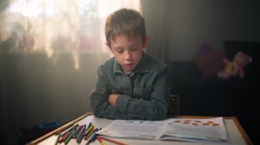 Çocuk evdeki çocuk odasında ödev yapıyor. Güzel beyaz bir okul çocuğu ders çalışıyor ve ödevlerini yapıyor. Yüksek kalite 4k görüntü