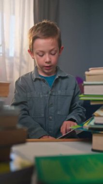 Ev ödevi yaparken kitap okuyup, elinde bir kitapla okula gitmeye odaklanmış bir öğrenci çocuk eğitimi kavramı. Yüksek kalite 4k görüntü