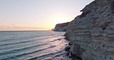 Kourion sahilinin Kıbrıs adası kıyılarındaki kayalıklı havadan görüntüsü. Dalgaların deniz kıyısına çarptığı yüksek uçurumları olan kayalık bir sahil. Yüksek kalite 4k görüntü