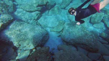 Kız suyun altına dalıyor ve tamam tabelasını elleriyle gösteriyor. Denizde eğlenceli bir tatil. Yüksek kalite 4k görüntü
