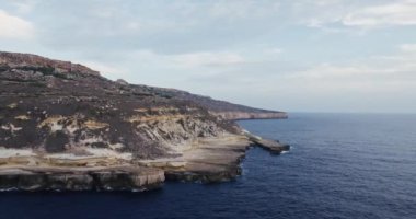 Malta adasındaki deniz kıyısının güzel doğa manzarasının havadan görünüşü. Akdeniz 'in dalgalarının çarptığı güzel sarp kayalık bir kıyı. Yüksek kalite 4k görüntü