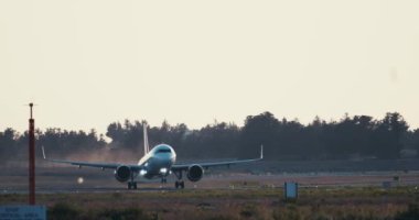 Gün batımında kalkan yolcu uçağının yavaş çekim videosu. Pist uçuşu, turizm ve hava yoluyla seyahat. Yüksek kalite 4k görüntü