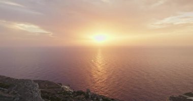 Malta hava manzaralı bir adada, denizin üzerinde gün batımı. Kayalıkları ve uçurumları olan güzel Akdeniz doğası. Yüksek kalite 4k görüntü