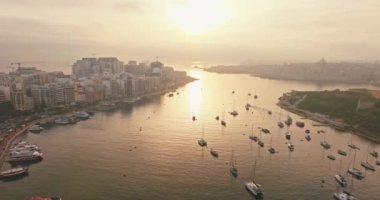 Gün batımında Malta Valletta 'da tekneli marinanın havadan görüntüsü. Akdeniz adasının rıhtım manzarasında güzel yatlar, turizm ve seyahat. Yüksek kalite 4k görüntü