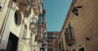 Malta 'nın Valletta adasındaki turistik eski sokakların mimarisi. Tarihi balkonlar ve Akdeniz 'in merkezindeki eski evler, turist kasabası, şehir manzarası. Yüksek kalite 4k görüntü