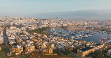Akdeniz 'in Harbor limanında demirlemiş yat ve tekneleriyle Malta Adası' ndaki Marina 'nın hava günbatımı manzarası. Yüksek kalite 4k görüntü