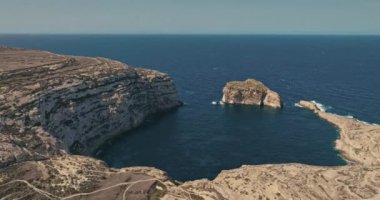 Malta 'nın Gozo adasındaki Mantar Kayası' nın havadan görünüşü. Akdeniz 'in dalgalarının çarptığı kayalık bir kıyı, doğa manzarası Avrupa turizmi. Yüksek kalite 4k görüntü