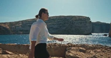 Tranquil Akdeniz Seyahat Videosunda Okyanus Dalgaları Kıyıya Çarpıyor ile Rocky Coast 'ta Yavaş Kadın Hareketi. Yüksek kalite 4k görüntü