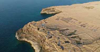 Gozo, Malta 'daki Zebbug adasındaki tuzluk fabrikası, hava manzaralı. Akdeniz 'deki denizden tuz çıkarmak, güzel doğal manzaralar. Yüksek kalite 4k görüntü