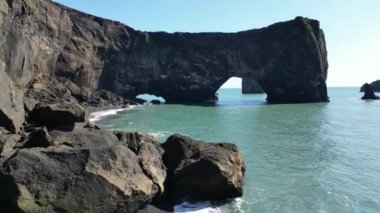 Dyrholaey, İzlanda 'yı sallıyor. Okyanus kıyısında kayalık bir kıyıda doğa manzarası olan bir turistik yer. Yüksek kalite 4k görüntü