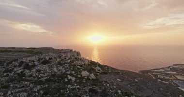 Malta hava manzaralı bir adada, denizin üzerinde gün batımı. Güneş Akdeniz 'de batıyor, doğanın manzarasındaki kayaların ve uçurumların güzel doğası. Yüksek kalite 4k görüntü