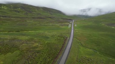 İzlanda 'nın kutup bölgesindeki bir dağ yolunun havadan görünüşü. Araba Tundra 'da yolda gidiyor. Yüksek kalite 4k görüntü