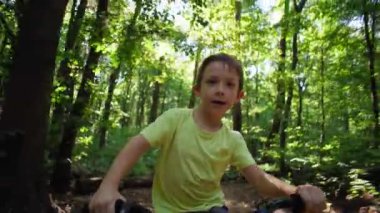 Heyecanlı Çocuk Bisiklet Gidonu 'nda pedal çeviriyor Aktif Yaşam Tarzı ve Açık Hava Eğlencesi Üzerine Yakın Odaklanma. Yüksek kalite 4k görüntü