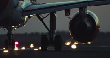 Lit Runway 'de Gece Yakından Uçak Tekerlekleri Havalimanı Yaşamını ve Yolcu Uçağı Seyahatini Gösteriyor. Yüksek kalite 4k görüntü