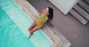 Mayolu bir kız havuzda yalnız başına rahatlıyor. Tatilde mutlu ve güzel bir kadın. Yüksek kalite 4k görüntü