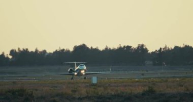 Pistten havalanan özel bir jetin yavaş çekim videosu. Günbatımı iş uçuşu, havacılık. Yüksek kalite 4k görüntü