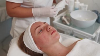 Profesyonel cilt bakımı kliniğinde güzellik prosedüründen önce hastanın yüzünü temizleme ve yıkama uzmanı. Yüksek kalite 4k görüntü