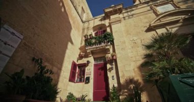 Mdina 'nın Malta adasındaki tarihi sokak mimarisi. Güzel taş duvarlar, antik yerlerde yürüyen bir turist. Yüksek kalite 4k görüntü