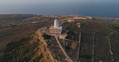 Malta 'nın Gozo adasındaki deniz fenerinin havadan görünüşü. Akdeniz 'in kayalık kıyılarının inanılmaz doğal manzarası. Yüksek kalite 4k görüntü