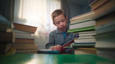 Çocuk evde bir kitap okumayı öğreniyor. Çocuk gelişir, öğrenir ve okula hazırlanır. Yüksek kalite 4k görüntü