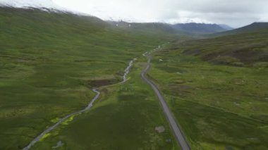 İzlanda tundrasındaki yolun havadan görünüşü. Kuzey Kutup Dairesi 'nin ötesindeki dağlara giden güzel bir yol, doğa. Yüksek kalite 4k görüntü