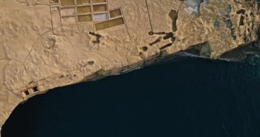 Gozo, Malta 'daki Zebbug adasındaki tuzluk fabrikası, hava manzaralı. Akdeniz 'in kıyılarında tuz çıkarma eylemi. Yüksek kalite 4k görüntü