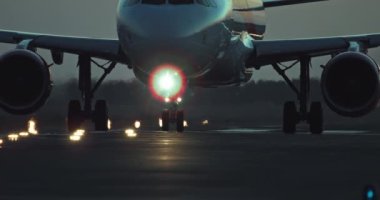 Bir yolcu uçağının tekerlekleri aydınlatılmış bir pist boyunca seyahat eder. Geceleri bir uçakla uçuyor. Yüksek kalite 4k görüntü
