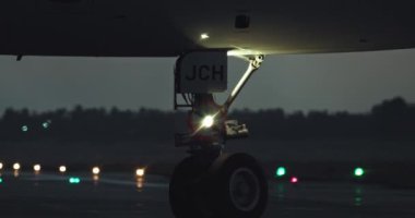 Yolcu Seyahati ve Gece Hava Yolcuları İçin Aydınlatılmış Havalimanı Pistindeki Gece Yakını Tekerlekleri. Yüksek kalite 4k görüntü