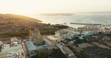 Gozo Malta 'nın Hondoq Qala adası. Günbatımında Akdeniz 'in şehir manzarası ve turist sahil şeridi. Yüksek kalite 4k görüntü