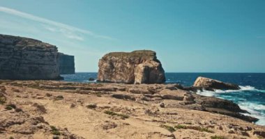 Malta 'nın Gozo adasındaki Mantar Kayası deniz manzarası. Akdeniz kıyısındaki kayalara çarpan deniz dalgalarının yavaş çekim videosu. Yüksek kalite 4k görüntü