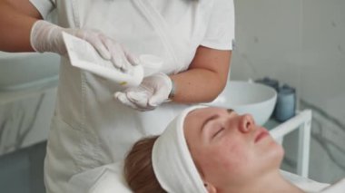 Profesyonel Estetisyen Kadın Yüzüne Parlayan Cilt İçin Temizleme Prosedürü Sonrası Klinikte Su Kaynatma Kremi Uyguladı. Yüksek kalite 4k görüntü