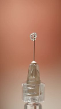 Sıvının çıktığı şırınganın iğnesine yakın çekim. Bir doktor bir hasta için ilaç enjeksiyonu hazırlar. Yüksek kalite 4k görüntü