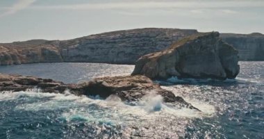 Gozo Malta 'daki Iconic Mantar Kayası' nın yanında Yürüyen Kadın Hava Görüntüsü ve Rocky Sahili 'nde Çarpışan Dalgalar. Yüksek kalite 4k görüntü