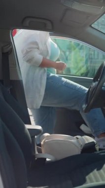 Kadın direksiyona geçer, emniyet kemerini takar ve arabayı çalıştırır. Güvenli sürüş kızı sürücüsü. Yüksek kalite 4k görüntü
