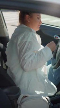 Kız arabaya biniyor, emniyet kemerini takıyor, arabayı çalıştırıyor. Kız işe ya da geziye araba sürmeye başlıyor. Yüksek kalite 4k görüntü