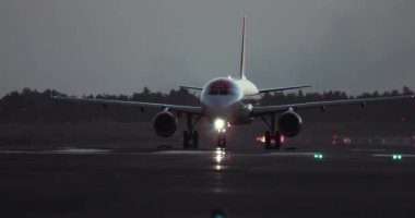 Bir uçak geceleyin havaalanının aydınlatılmış pisti boyunca seyahat eder. Hava yolculuğu ve seyahat. Yüksek kalite 4k görüntü