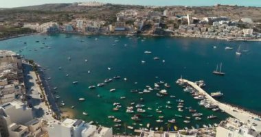 Bugibba, Malta 'daki marinanın havadan görüntüsü. Yatları ve tekneleri olan turizm ve seyahat limanı manzaralı güzel bir şehir. Yüksek kalite 4k görüntü