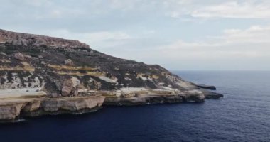 Malta adasındaki denizin kayalık kayalık kıyılarının hava manzarası. Akdeniz 'in dalgaları kıyıya çarpıyor. Yüksek kalite 4k görüntü